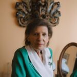 Pani Barbara ubrana w zielony żakiet spogląda prosto w obiektyw z lekkim uśmiechem.